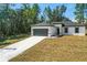 Single-story home with gray roof and attached garage, featuring a long driveway at 161 Marion Oaks Trail, Ocala, FL 34473