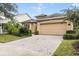 Tan one-story house with a two-car garage and well-maintained landscaping at 1381 Hazeldene Mnr, Deland, FL 32724