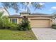 Tan one-story house with two-car garage and landscaped yard at 1381 Hazeldene Mnr, Deland, FL 32724