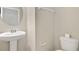 Small bathroom with pedestal sink, toilet, and a round mirror at 1209 Seburn Rd, Apopka, FL 32703