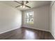 Bedroom with dark wood floors, ceiling fan and window at 709 Del Rio Way, Kissimmee, FL 34758