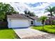 Single-story house with a two-car garage, and lush green lawn at 709 Del Rio Way, Kissimmee, FL 34758