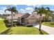 Tan one-story house with two palm trees in front and a two car garage at 4070 Island Lakes Dr, Winter Haven, FL 33881