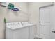 Bright laundry room, washer, dryer, and shelving at 4070 Island Lakes Dr, Winter Haven, FL 33881