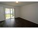 Spacious bedroom with dark wood-look flooring and sliding glass doors to the backyard at 1050 Abell Cir, Oviedo, FL 32765