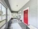 Screened porch with red door, seating, and glass top table at 1017 Mabbette St, Kissimmee, FL 34741