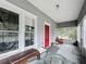 Relaxing screened porch with red door and seating at 1017 Mabbette St, Kissimmee, FL 34741