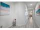 Light and airy hallway with beach-themed wall art and vinyl plank flooring at 3179 Rodrick Cir, Orlando, FL 32824