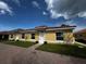 Front view of three-unit building with yellow exterior and tile roofs at 1652 Cumin Dr, Poinciana, FL 34759