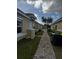 Brick walkway between two buildings, showing AC units and landscaping at 1652 Cumin Dr, Poinciana, FL 34759