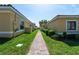 Brick pathway between two houses with lush green landscaping at 1652 Cumin Dr, Poinciana, FL 34759