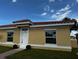 Front view of a single-Gathering home with yellow exterior and tile roof at 1652 Cumin Dr, Poinciana, FL 34759