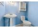 Small bathroom with pedestal sink, toilet, and wall cabinet at 926 Everett St, Lake Alfred, FL 33850