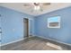 Light blue bedroom with wood-look floors, ceiling fan, and mirrored closet at 926 Everett St, Lake Alfred, FL 33850