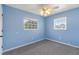Light blue bedroom with grey carpet and two windows at 926 Everett St, Lake Alfred, FL 33850