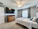 Well-lit bedroom, featuring a dresser, TV, and a ceiling fan at 24341 Milford Dr, Eustis, FL 32736
