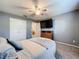 Spacious bedroom with a comfortable bed, en-suite bathroom access, and a large TV at 24341 Milford Dr, Eustis, FL 32736