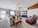 Spacious living room featuring a large sectional sofa, fireplace, and a large TV at 24341 Milford Dr, Eustis, FL 32736