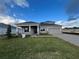 Two-story house with a large front yard, gray siding, and a three-car garage at 3255 Roseville Dr, Apopka, FL 32712