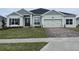 Gray two-story house with a three-car garage and landscaped lawn at 3271 Roseville Dr, Apopka, FL 32712