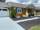 Bright yellow house with white garage door, landscaping, and walkway at 8272 Le Mesa St, Orlando, FL 32827