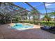 Screened pool and spa with lounge chairs, overlooking a golf course at 11227 Macaw Ct, Windermere, FL 34786