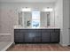 Modern bathroom with double vanity, marble tile, and a large mirror at 13663 Ritta Island Dr, Orlando, FL 32827