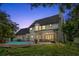 Two-story house with a pool, lit up at night at 12200 Treetop Ct, Orlando, FL 32832