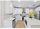 Modern white kitchen with large island and stainless steel appliances at 12200 Treetop Ct, Orlando, FL 32832