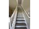 Modern staircase with wood-look laminate treads and white balusters at 3643 Daydream Pl, Saint Cloud, FL 34772