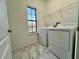 Laundry room with washer, dryer, shelving, and a window at 1431 Pacific Rd, Poinciana, FL 34759