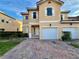 Two-story townhome with a white garage door and landscaped front yard at 1431 Pacific Rd, Poinciana, FL 34759