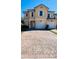 Two-story townhome with tan exterior, paver driveway, and attached garage at 1431 Pacific Rd, Poinciana, FL 34759