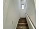 Carpeted staircase with a modern white railing leading to the upper level at 1431 Pacific Rd, Poinciana, FL 34759