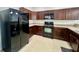 Modern kitchen with dark wood cabinets and black appliances at 1431 Pacific Rd, Poinciana, FL 34759