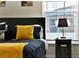Bedroom with king-size bed, yellow pillows, and nightstand at 188 Ridgemont Ct, Davenport, FL 33896