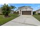 Two-story house with a brown garage door and landscaped yard at 957 Whispering Cypress Ln, Orlando, FL 32824