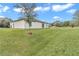 Spacious backyard with grassy area, sloped terrain, and tree at 1154 Sea Pines Ct, Tavares, FL 32778