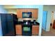 Well-equipped kitchen featuring black appliances and wood cabinets at 8101 Resort Village Dr, Orlando, FL 32821