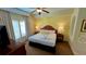 King-size bed in a bright bedroom with a ceiling fan, dresser, and ensuite bath at 8101 Resort Village Dr, Orlando, FL 32821