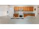 View of kitchen with oak cabinets, white appliances, and granite countertops at 117 Verbena St, Davenport, FL 33837