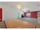Spacious living room with large windows, red accent wall, and chandelier at 117 Verbena St, Davenport, FL 33837