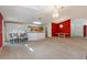 Open living room and dining area with red accent walls and chandelier at 117 Verbena St, Davenport, FL 33837