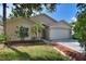 Single-story house with a two-car garage and well-maintained lawn at 117 Verbena St, Davenport, FL 33837