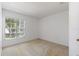 Simple bedroom with large window, neutral walls, and carpeted floor at 117 Verbena St, Davenport, FL 33837
