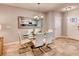 Dining area with a glass table and white chairs, reflecting kitchen in mirror at 6138 Galloping Dr, Apopka, FL 32712