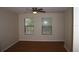 Bright bedroom with wood-look floors, ceiling fan, and two windows at 513 Ramsdell Ave, Altamonte Springs, FL 32714