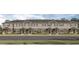 Exterior view of a row of townhouses with gray siding and dark gray roofs at 6130 Galloping Dr, Apopka, FL 32712