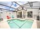 Private screened pool with safety fence and colorful chairs at 8988 Stinger Dr, Champions Gate, FL 33896