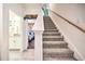 Carpeted staircase with wooden railing leading upstairs at 8988 Stinger Dr, Champions Gate, FL 33896